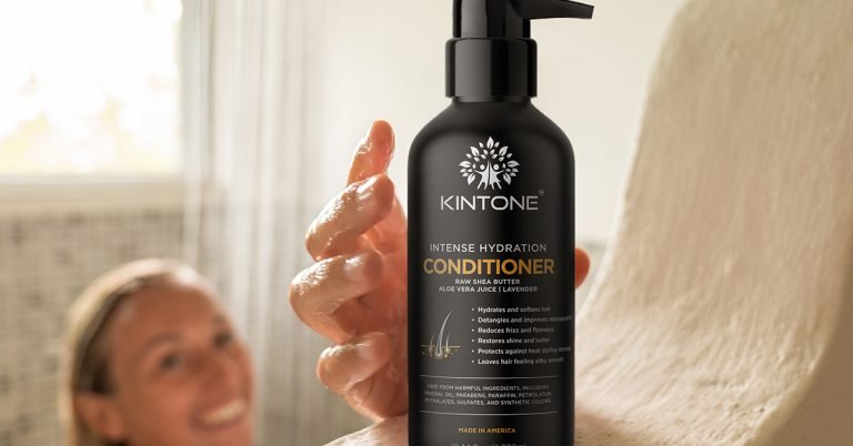 A smiling white woman grabs a big black bottle of Kintone Intense Hydration Conditioner. Cultural appropriation or cultural appreciation?